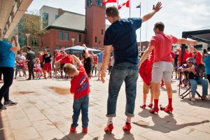 Walkers wearing the red heels stand in a circle around Shannon Butt who is leading the pre-walk stretch.