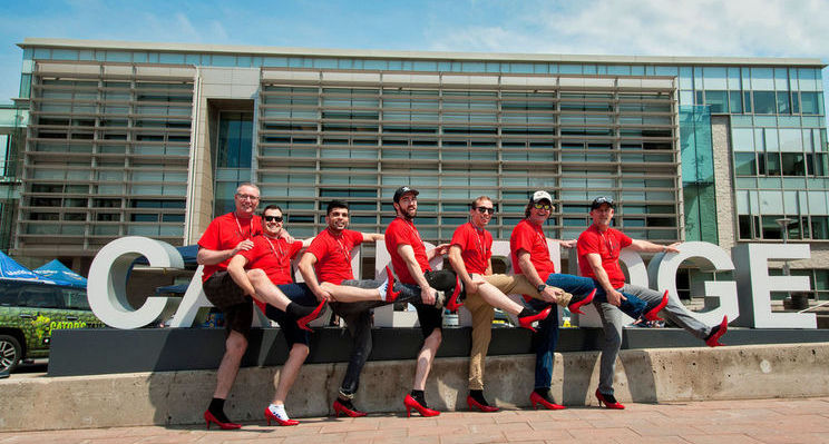 Walk a Mile participants pose with red high heels