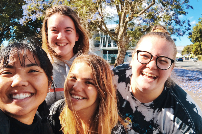 four girls smiling outdoors