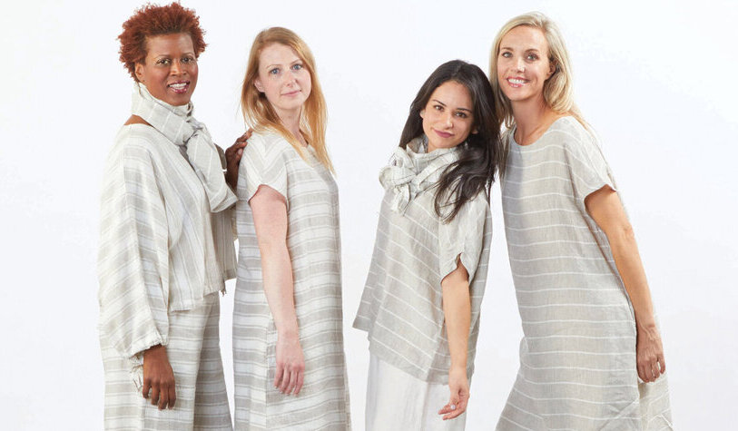 four women in grey and white linen outfits