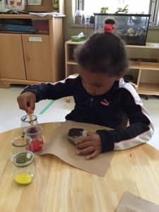 A child paints a rock