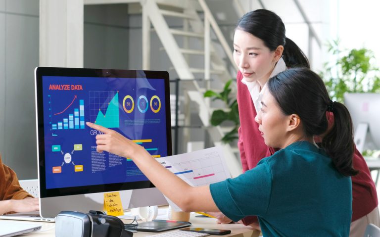 Two women analyzing data on a computer screen