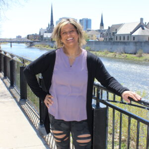 Photo of woman in purple shirt standing in front of the grand river