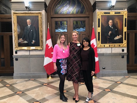 YWCA Cambridge's Roz Gunn and YWKW's Jennifer Breaton stand inside Parliament with MP Bardish Chagger