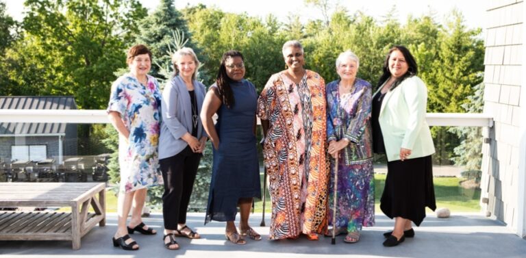 The six 2024 Women of Distinction recipients stand together on the outdoor deck of Whistle Bear Golf Club