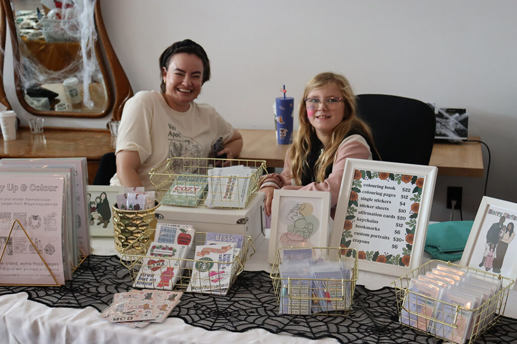 A couple of vendors at the 2023 Feminist Night market with all of their products displayed for sale