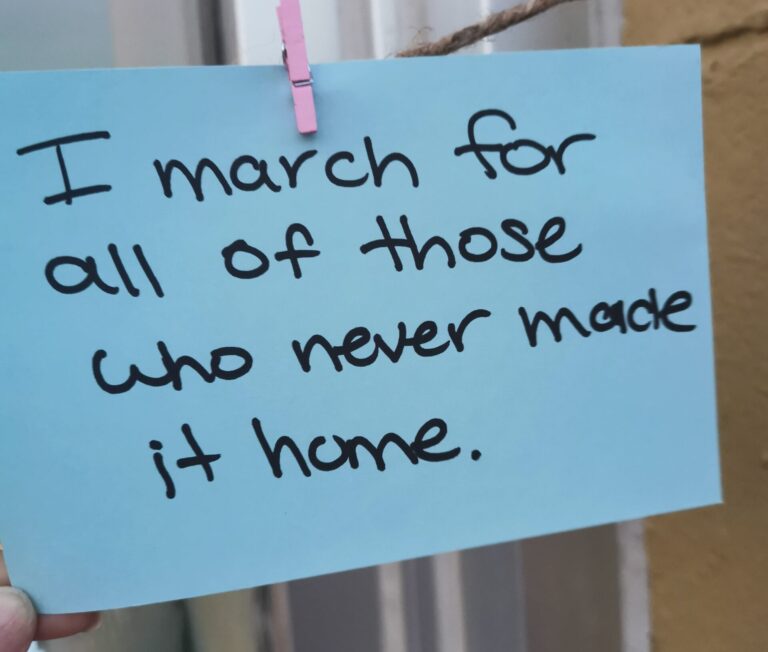 Close up of sticky note with the following note on it: I march for all of those who never made it home.