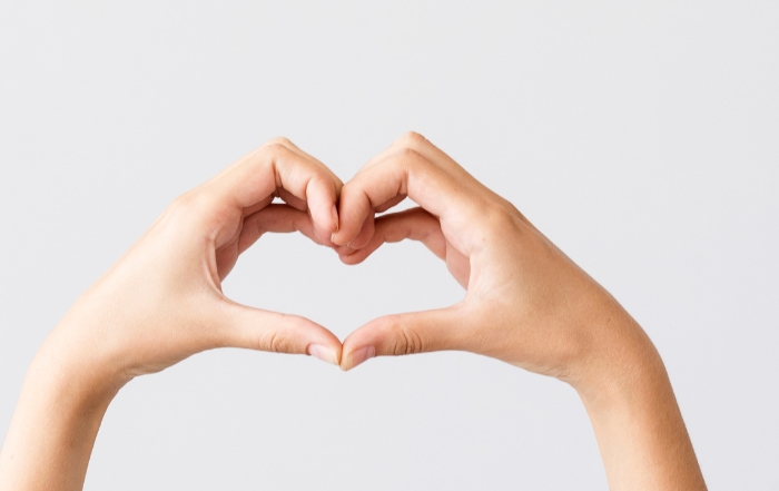 Photo of two hands making the shape of a heart