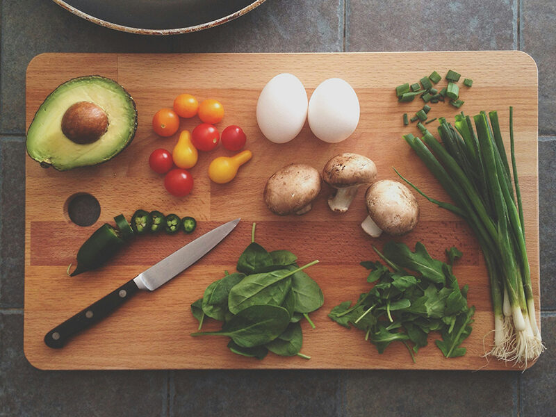 Cutting board with a knife and several fresh ingredients