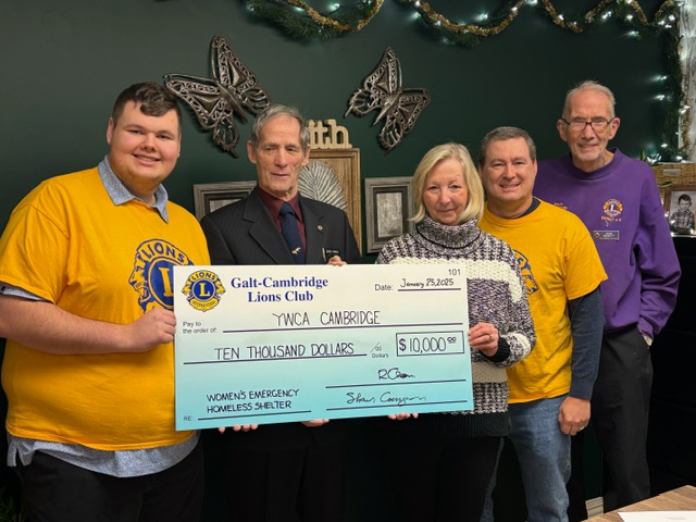 A photo of Galt Cambridge Lions Club members with YWCA Cambridge CEO Kim Decker. Theyre holding a large cheque showing the $10,000 donation from Lions Club