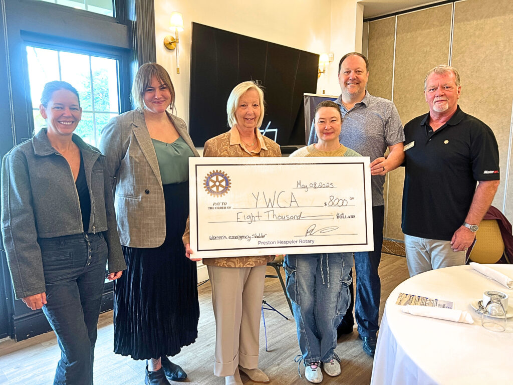 YWCA Cambridge CEO Kim Decker and manager of donor relations and communications, Britteny Blackman, stand with members of Cambridge Preston-Hespeler Rotary, all holding up a giant cheque for $8,000