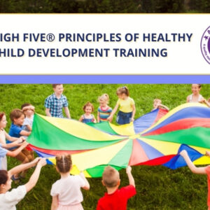 Children play the big parachute game. Title of training event top right.