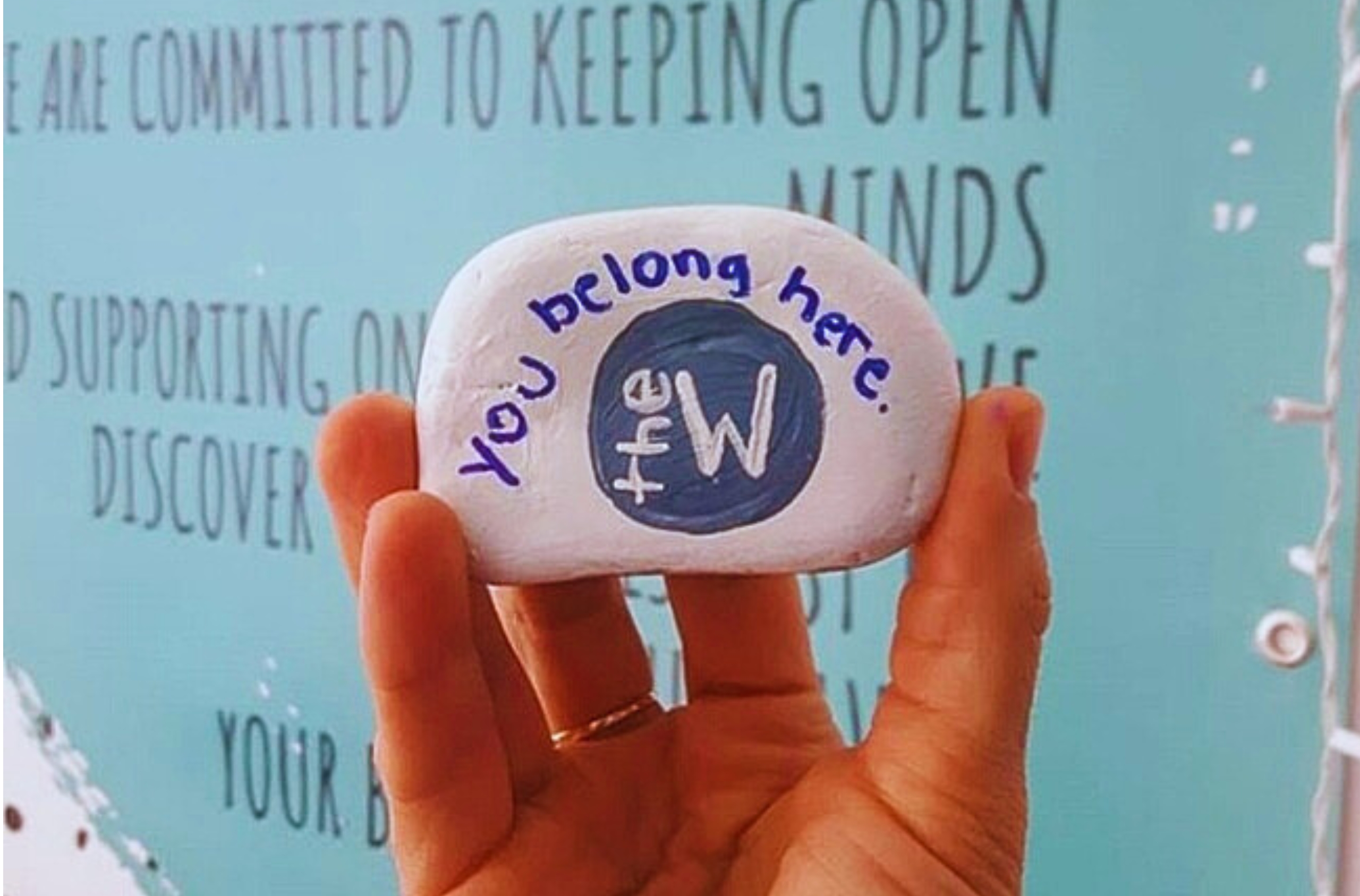 You Belong Here painted on a rock with The W logo