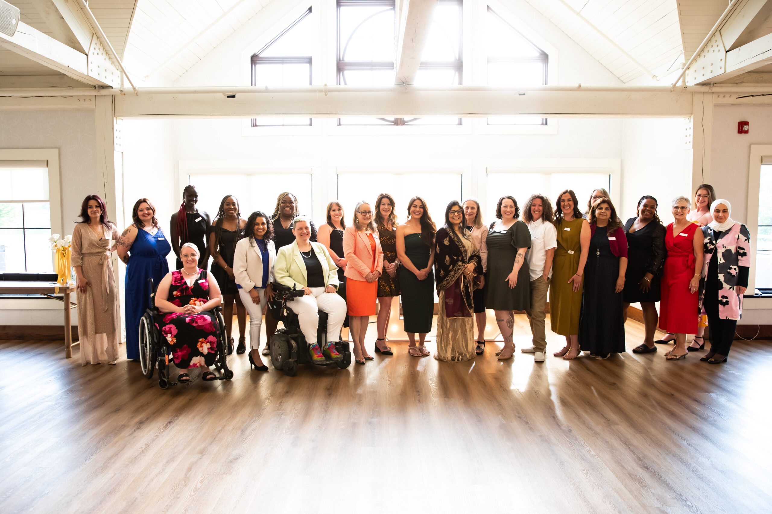 Photo of all 24 2025 Women of Distinction Award nominees, gathered in front of the windows in the Whistle Bear ballroom. Photo by Die Una Photography