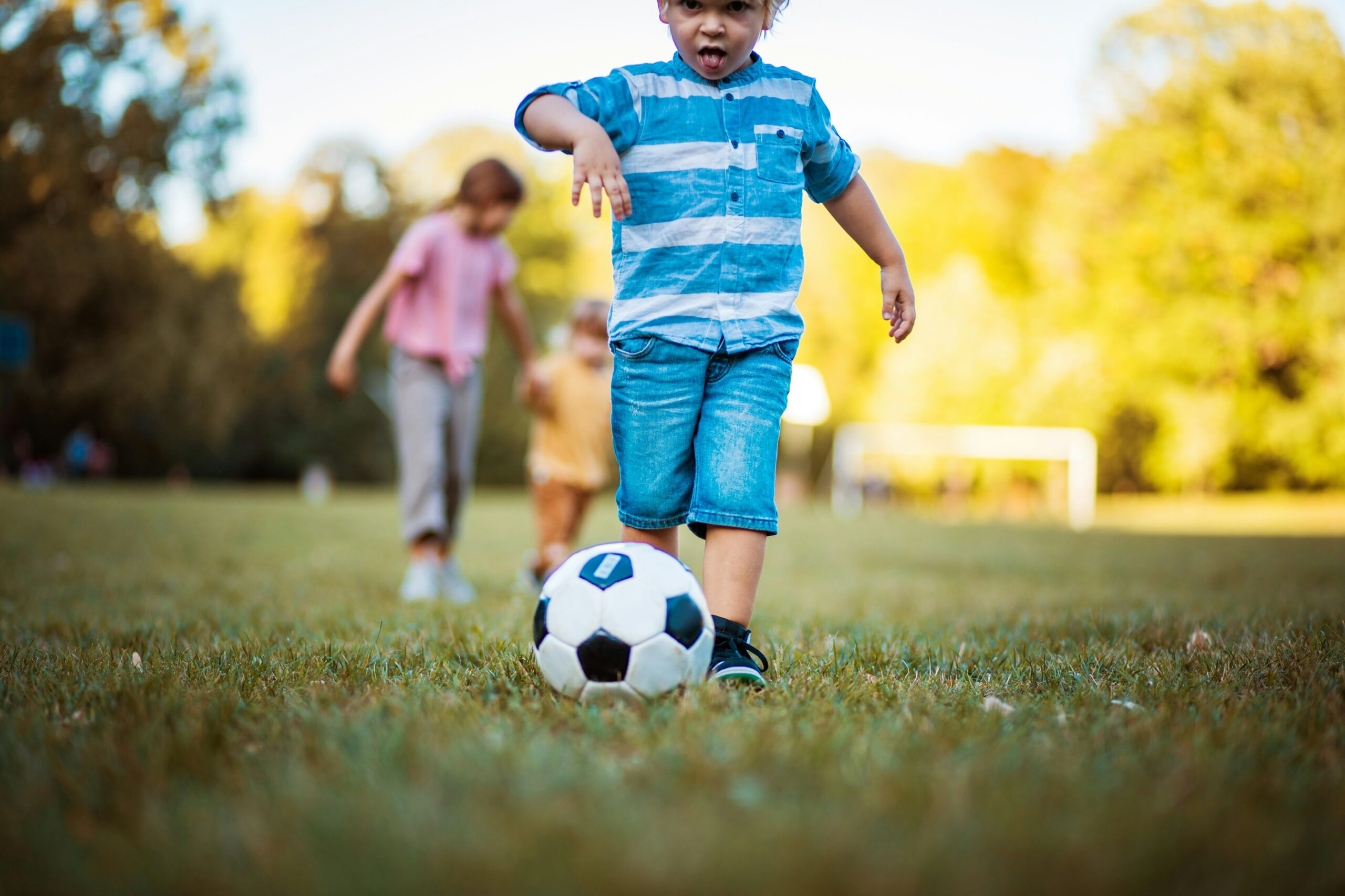 young boy running after a soccer ball