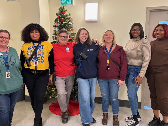 shelter staff standing in front of christmas tree