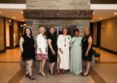 Six of the Women of Distinction Recipients stand together in front of a fireplace. They are: Sidney MacDonald, Kay Crawford, Crystal LeForest, Mary Jane LeBlanc, Lorraine Harris, and Brenda Walsh