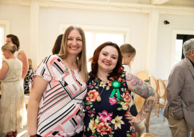 two women stand in a well lit room