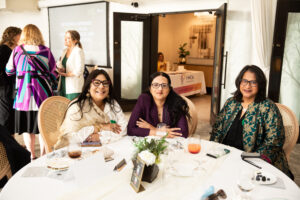 three women sit at a gala table