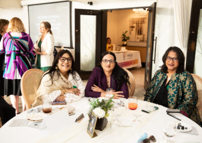 three women sit at a gala table